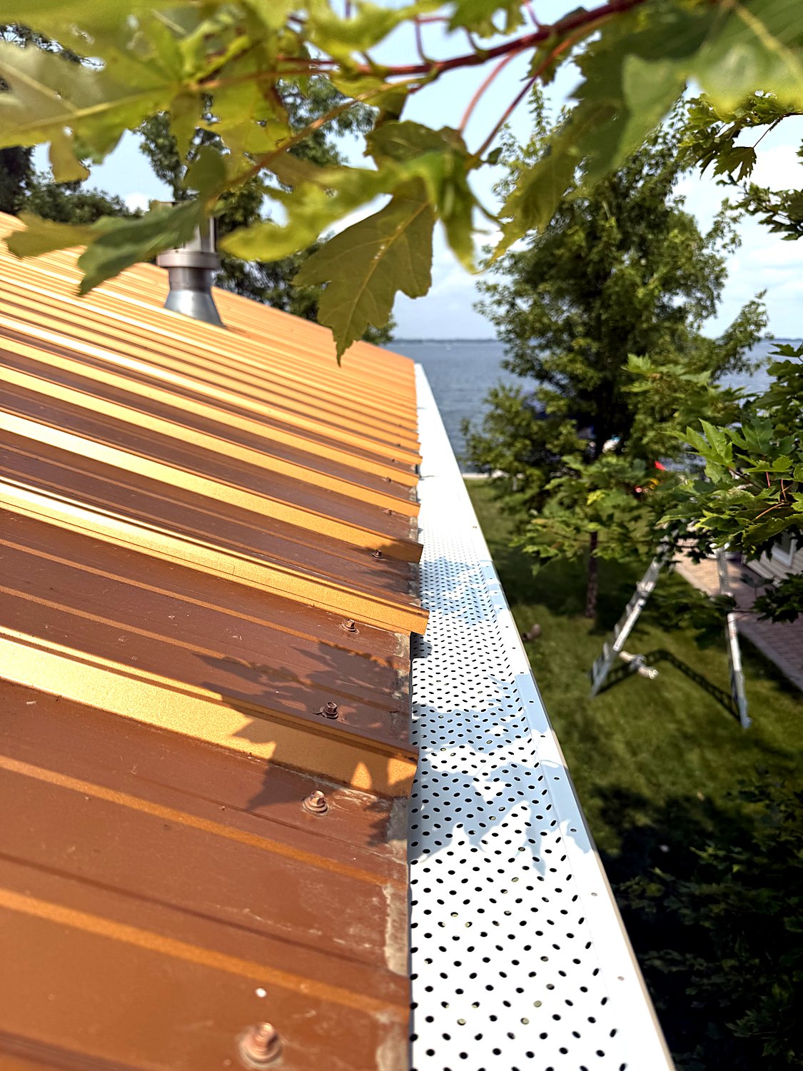 Gutter guards installed over a standing-seam metal roof
